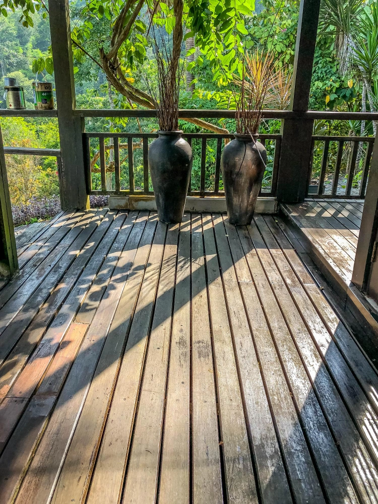 Custom-built wooden patio deck surrounded by lush greenery